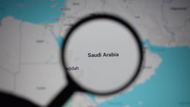 Magnifying glass focusing on Saudi Arabia map highlighting Riyadh and Jeddah, symbolizing Middle East geopolitics, oil export routes, tourism growth, pilgrimage travel, and strategic global trade.