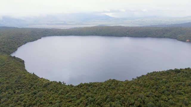 A sweeping aerial perspective of Buey Lagoon, embraced by thick vegetation, with a tranquil water surface reflecting the sky.