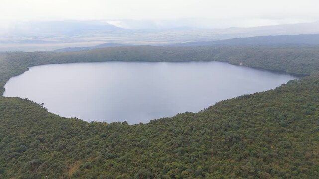 A scenic aerial view showcasing the tranquil waters of Buey Lagoon, bordered by lush green vegetation in Purace National Park, Cauca, Colombia.