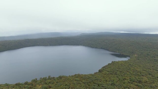 Overcast skies hover over the serene Buey Lagoon, bordered by rich greenery in Purace National Park.