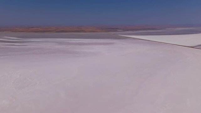 Aksaray, Turkey. Summer aerial view of Tuz Golu salt lake near Sereflikochisar showing pink-tinted salt evaporation ponds, access roads and mining fields under bright sun.. Aerial View