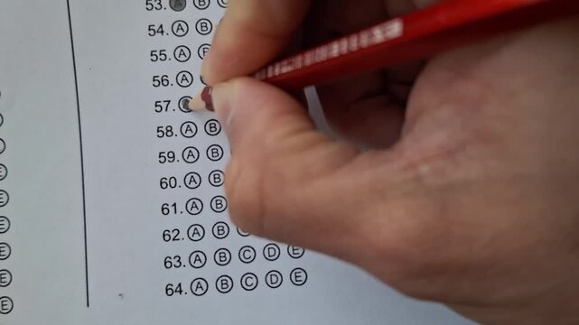 Hand marks a test with a red pencil