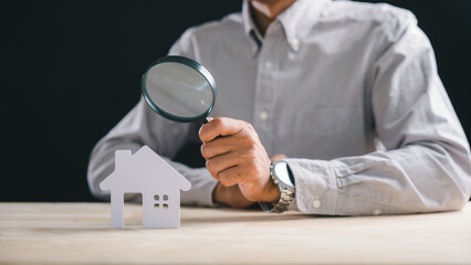 Real estate appraisal for house property, inspector uses magnifying glass to search for home valuation, professional appraiser closely examines asset details for accurate property assessment