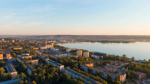 Russia, Votkinsk. Embankment with a dam and factories. Votkinsk is a city in the Udmurt Republic. Sunset time. Drone footage