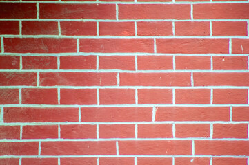 Obraz premium A vibrant red brick wall, showcasing classic texture and patterns. Ideal for backgrounds, construction, or architectural design projects