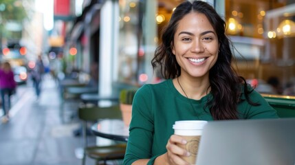 Fototapeta premium Happy young woman enjoying coffee and working on laptop at outdoor cafe in urban setting with vibrant atmosphere and soft sunlight