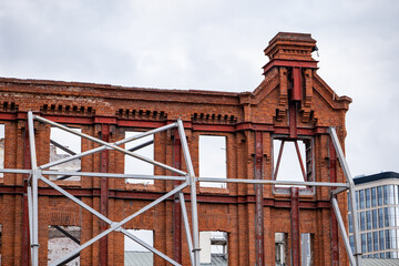 Facade reconstruction showing old brick building preserved with steel support structure