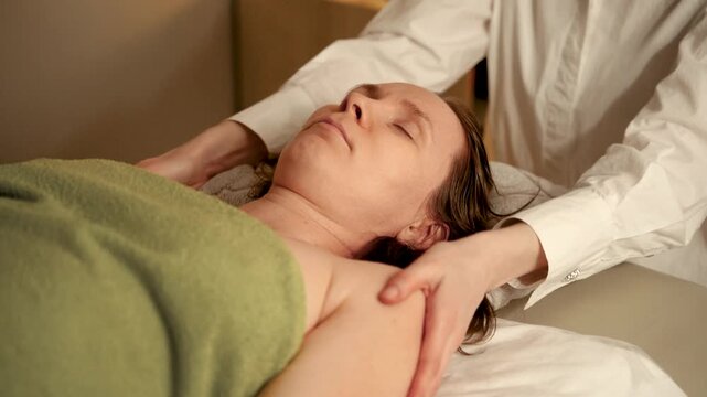 Professional massage therapist giving shoulder massage in a spa salon