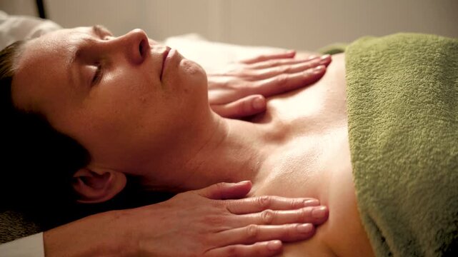 Professional massage therapist giving shoulder massage in a spa salon