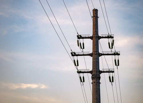 Power lines extending from an electric utility pole against a cloudy sky