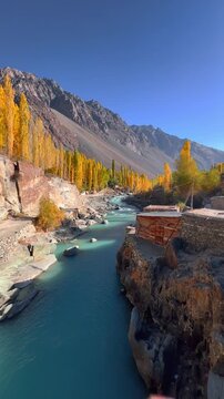 Cinematic 4K vertical wide angle footage of Majestic Autumn Landscape of Gupis Valley with Winding Gilgit River and Golden Poplar Trees, Gilgit-Baltistan, Pakistan