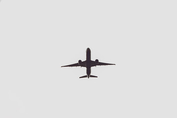 Fototapeta premium Airplane silhouette overhead flying, representing global travel, journey, and freedom concept