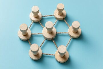Obraz premium Connected Pins: Wooden pins interlinked, representing teamwork and unity, with a touch of simplicity.