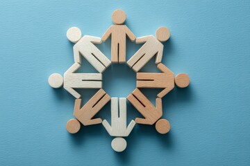 Obraz premium Unity in a Circular Embrace: A harmonious arrangement of diverse wooden figures forms a circle, symbolizing unity, support, and collaboration on a soft blue background.