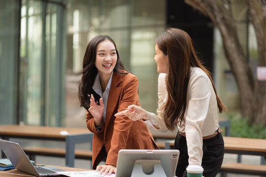 Two female coder or developer working overtime using a computer display in problem solving.