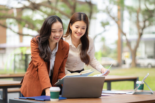 Two female coder or developer working overtime using a computer display in problem solving.