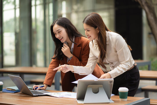 Two female coder or developer working overtime using a computer display in problem solving.