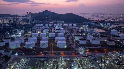 Aerial view industrial storage tank oil and gas chemical, Global fuel supply oil and gas, Industrial oil and gas storage tank farm facility energy reserve infrastructure fuel supply chain at night.
