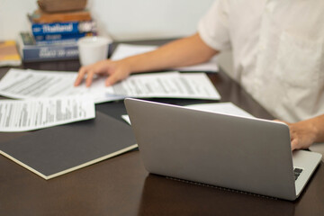 Remote work concept Male freelancer is reading business data on document while working at home