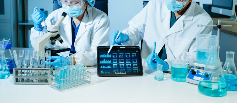 Medical scientists performing biotechnology laboratory research with DNA molecular analysis, microscope testing and digital healthcare technology