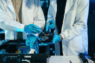 Engineers repairing computer hardware and hard drive in a technology lab. Concept of data storage, cybersecurity, digital infrastructure, electronics maintenance