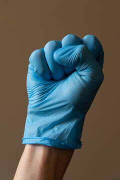Hand wearing blue medical glove showing various gestures and signs against neutral background. Concept of hygiene, protection and communication with hand signals.