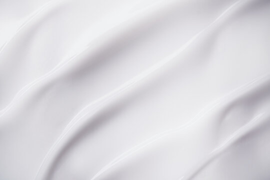 Smooth white cream texture forming elegant flowing waves and swirls