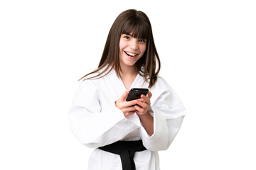 Fototapeta premium Little Caucasian girl doing karate over isolated background surprised and sending a message