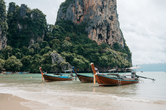Long tail boats at Railay West Beach with limestone cliffs in Krabi