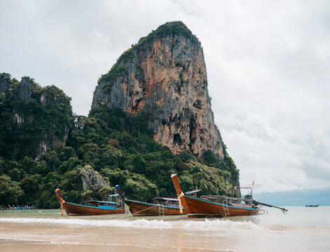 Long tail boats on Railay West Beach with limestone karst cliffs