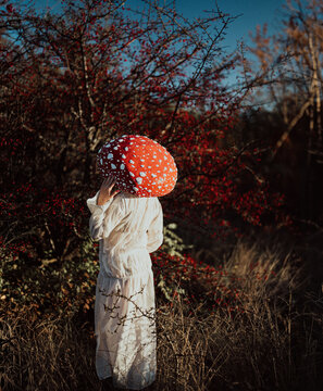 Red mushroom woman in hat cosplay inspired by nature and fairy tale
