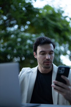 Entrepreneur reading message on smartphone in outdoor workspace