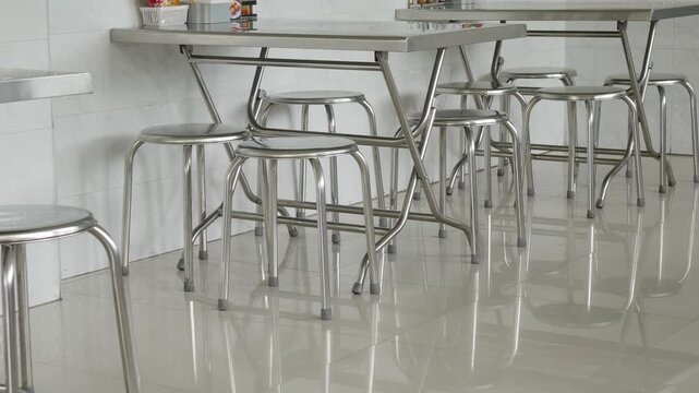 stainless steel round stools and folding tables in a clean modern Asian restaurant