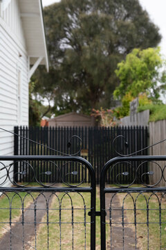 Two sets of black gates and a driveway.
