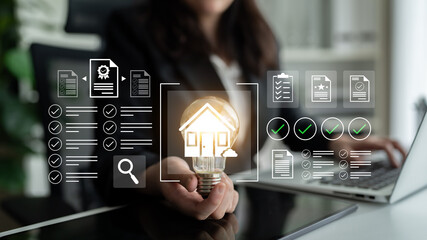 A business professional showcases a light bulb with a house icon in a modern office, symbolizing...