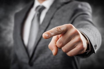 Obraz premium Close-up of a businessman in a gray suit pointing his finger at the camera