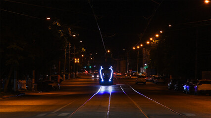 New modern high-speed tram on a night street in the city