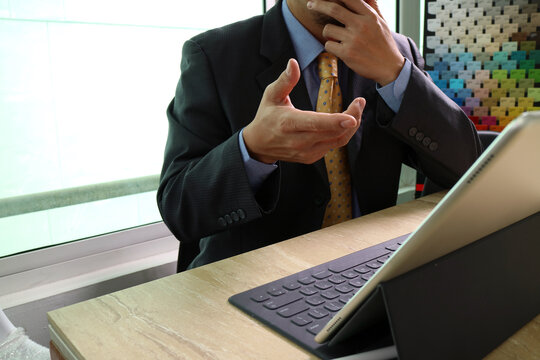 Businessman Thinking While Using Tablet at Desk with Color Sample Palette Background