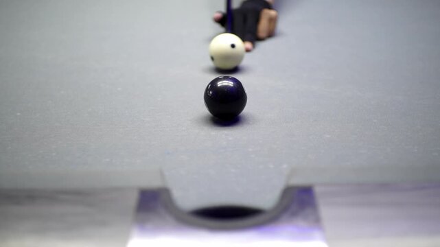 Billiard balls in a line heading towards a pocket on a pool table during a game of pool