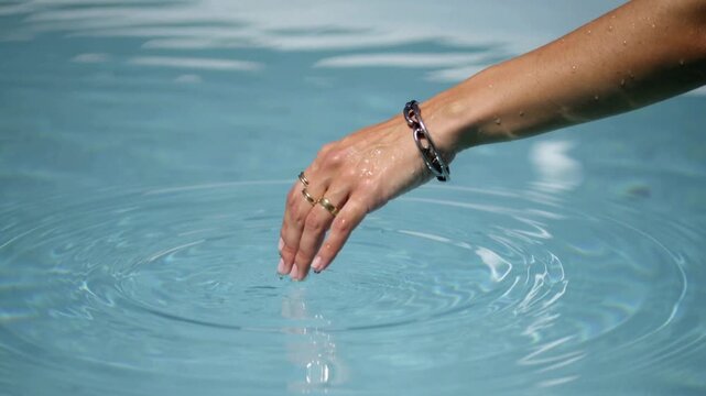 Woman's Hand Touching Rippling Pool Water image (124