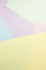 Pastel colored paper layering, forming a geometric abstract background. Soft light creating a subtle texture and shadow
