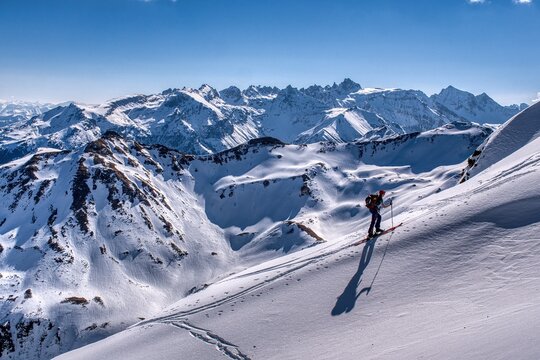 Snowy Mountain Skiing. Skier Carving Fresh Snow Against Majestic Mountain Backdrop. Remote Mountain Landscape Illustrating Solitude Alongside Thrills Of Winter Sports. Ski tour to the Hochfinsler moun