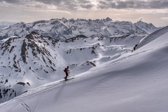  A ski tourer ascends the beautiful Swiss mountains. Ski mountaineering in winter. Climbing Mount Hochfinsler. High quality photo
