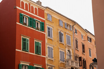 Fototapeta premium Vibrant Cityscape of Old Buildings with Shutters and Flowers