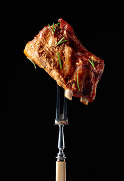 Grilled pork ribs on a fork.