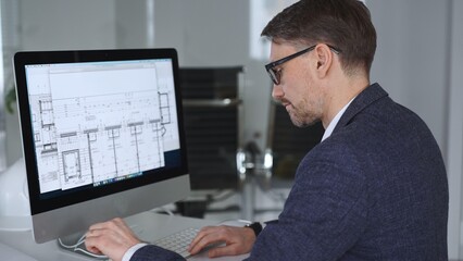 Naklejka premium Architect developing building blueprint on computer, engineering and urban planning a new construction project. Business and architecture concept