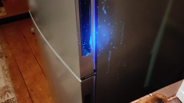 Ultraviolet flashlight illuminating refrigerator surface revealing hidden stains and marks invisible without UV light