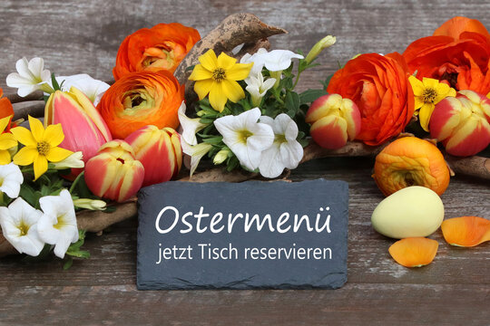 Tafel mit der Aufschrift Ostermen&uuml; jetzt Tisch reservieren umgeben von Blumen.