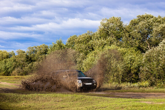 Japanese SUXV moving by a puddle making a lot of dirt splashes