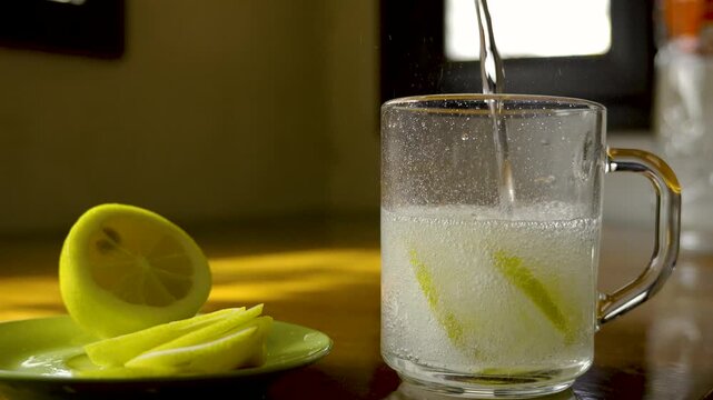Cinematic Slow Motion of Fresh Sparkling Water with Lemon Slices in Glass on Wooden Table, 4K 120fps
